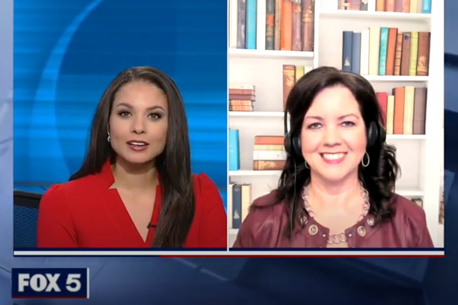 Two women appear on a Fox 5 news segment. One is in the studio, wearing a red blouse, while the other joins remotely with a bookshelf background, dressed in purple and smiling. The media coverage highlights their seamless interaction despite the different settings.