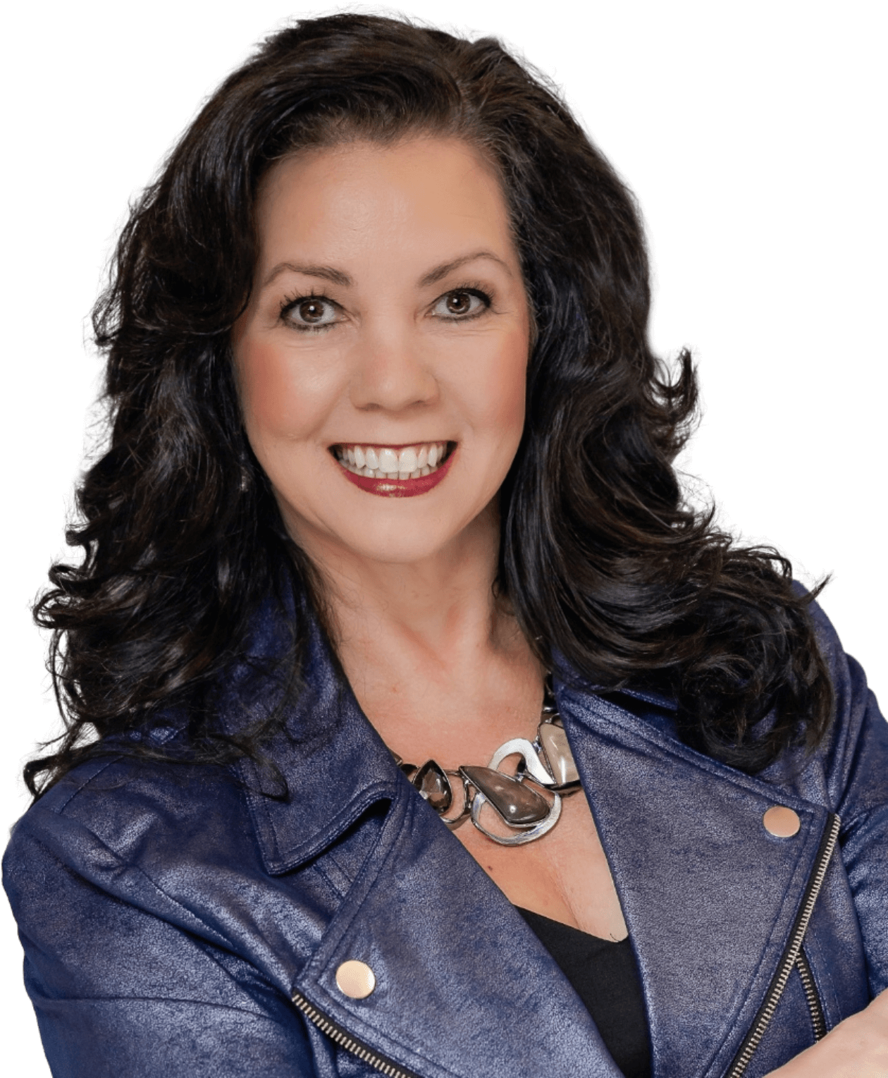 Angela Buttimer, a woman with long dark hair, wearing a blue leather jacket and a silver necklace, smiles while looking into the camera.