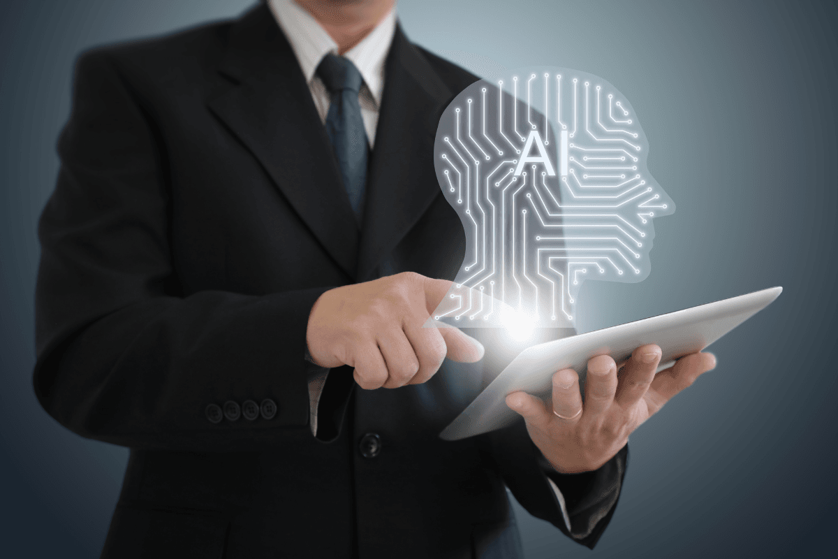 A person in a suit holding a tablet, displaying a digital human head with circuit patterns and the letter 'A', symbolizing AI for Leadership and highlighting leadership benefits in today’s tech-driven world.